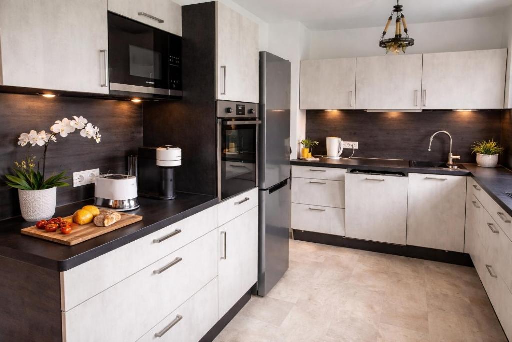 a kitchen with white cabinets and black counter tops at Allgäu Space in Marktoberdorf