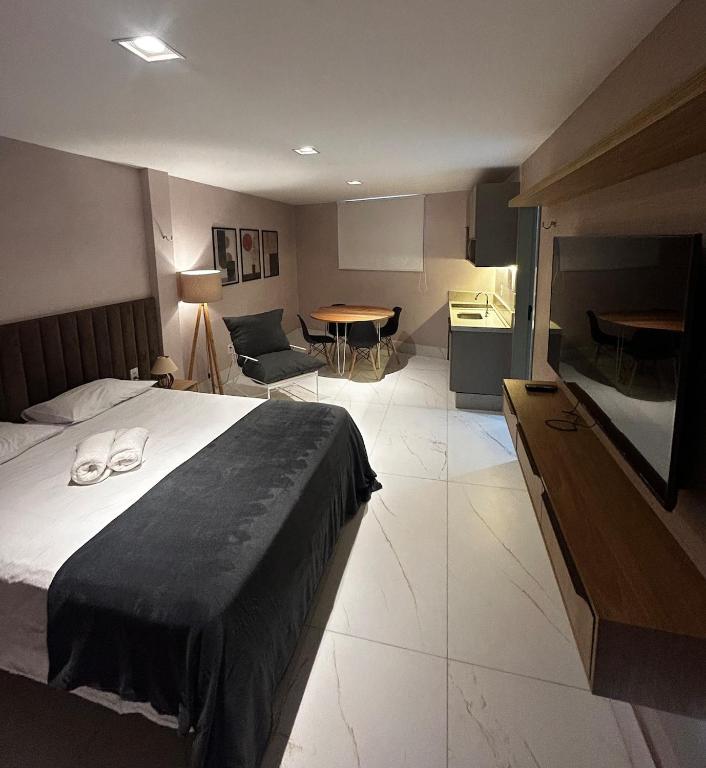 a hotel room with a bed and a table and chairs at Seridó Acomodações in Caicó