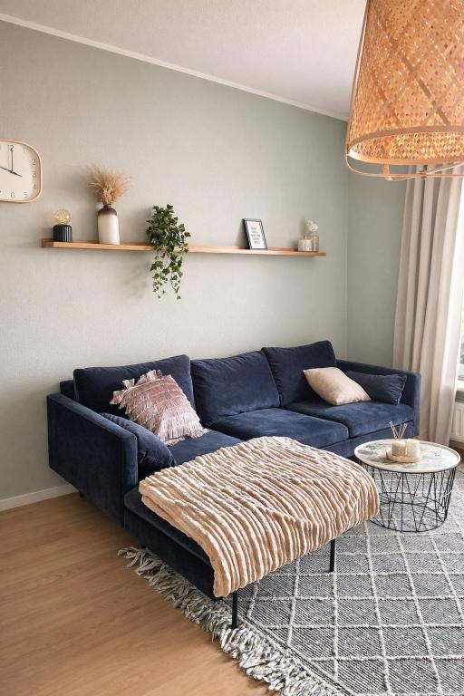 a living room with a blue couch and a table at Schöne 3-Zimmer City-Wohnung in Neumünster
