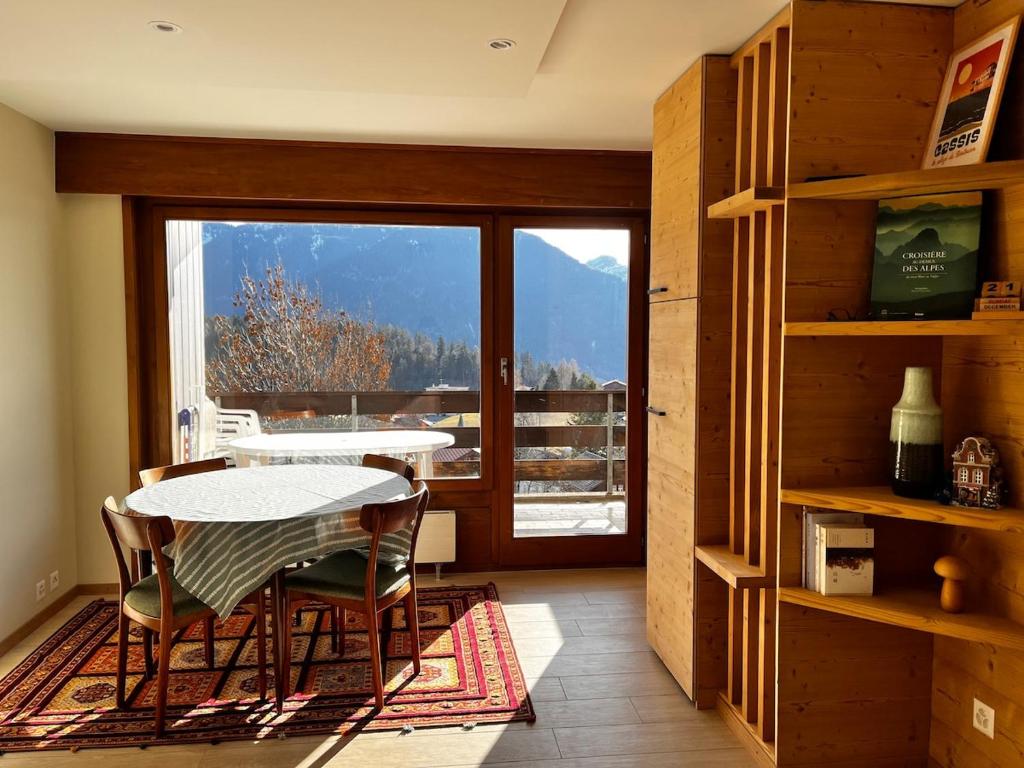 a room with a table and chairs and a balcony at Beautiful mountain apartment in Leysin