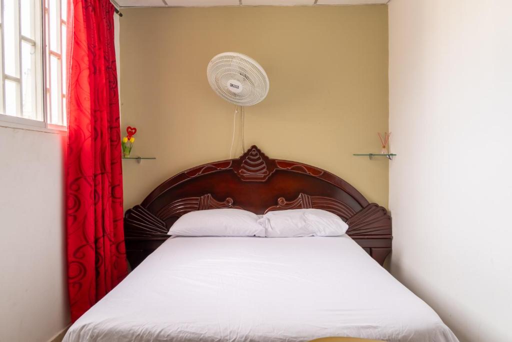 哥伦比亚港Donde Mire的一间卧室配有一张带红色窗帘的木床