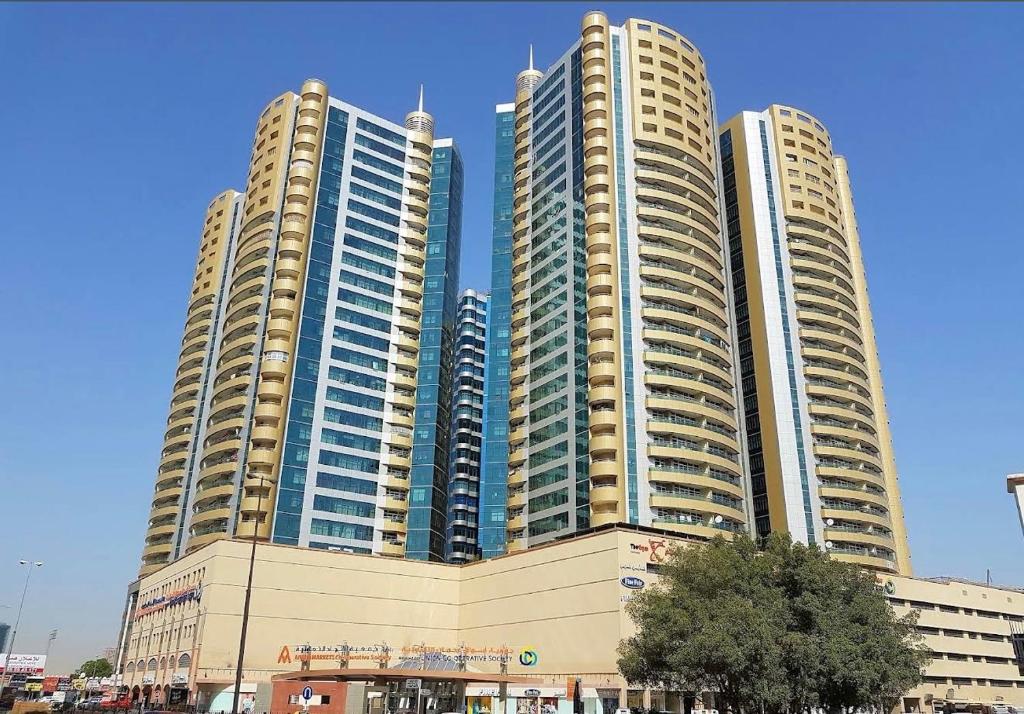 un gruppo di tre edifici alti in una città di Cozy Room Rashdiya 1 Ajman ad Ajman