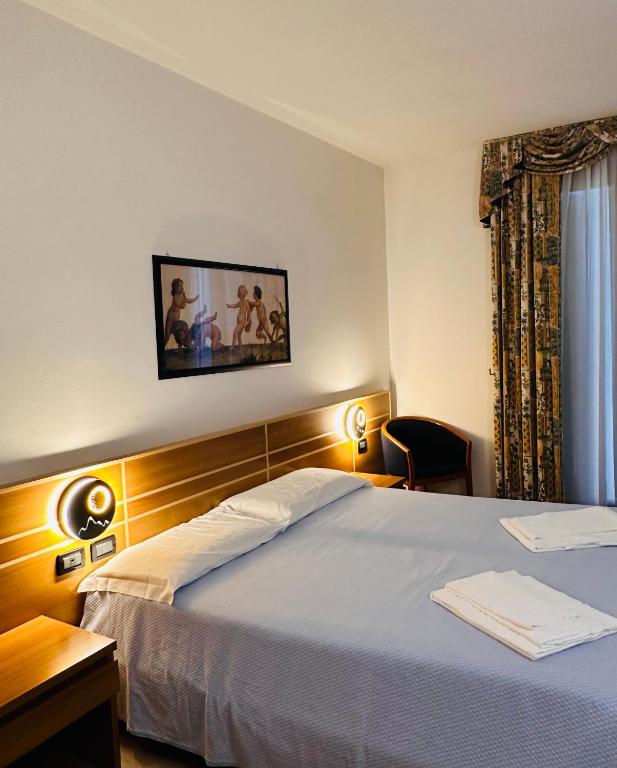 a hotel room with a bed and a window at Hotel Oasi Este in Este