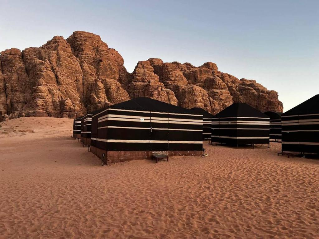 瓦迪拉姆Wadi Rum Desert Experience的沙漠中的一群黑白建筑