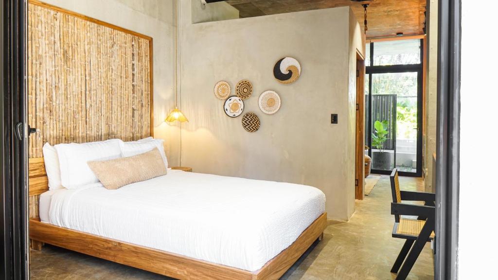 a bedroom with a white bed and a window at The Quiet Garden in Jacó