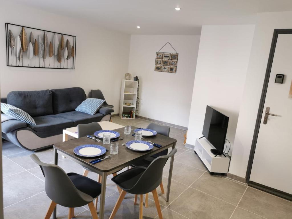 a living room with a table and a couch at maison de village in Renaison