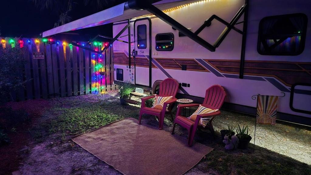 two chairs and a table in front of an rv at Edith the Happy Camper in High Springs