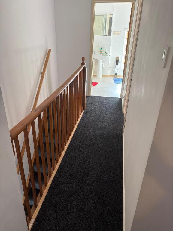 a stairway with a wooden rail and a hallway at Treforest Cwtch House in Treforest