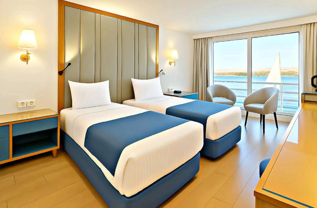 two beds in a hotel room with a view of the ocean at Five-Star Deluxe River Kruz from Aswan to Luxor 3 Nights in Aswān
