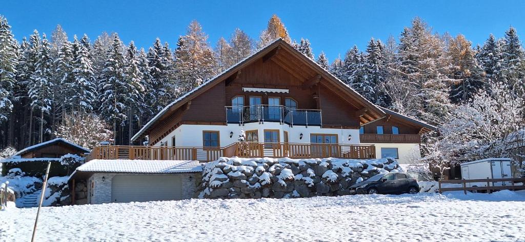 una grande casa nella neve con gli alberi di Apartmenthaus Kammblick a Gröbming