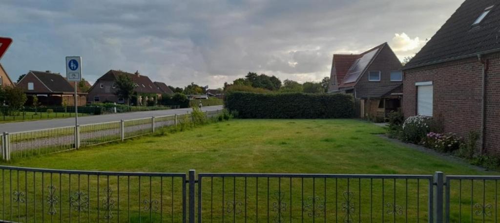 a yard with a fence in front of a house at Ferienhaus Seestern in Dornum