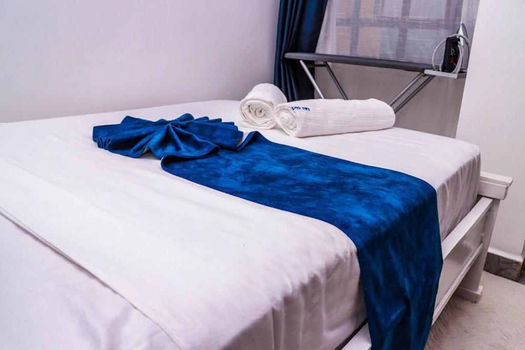 a bed with a blue blanket and towels on it at EnE Homes in Kisumu