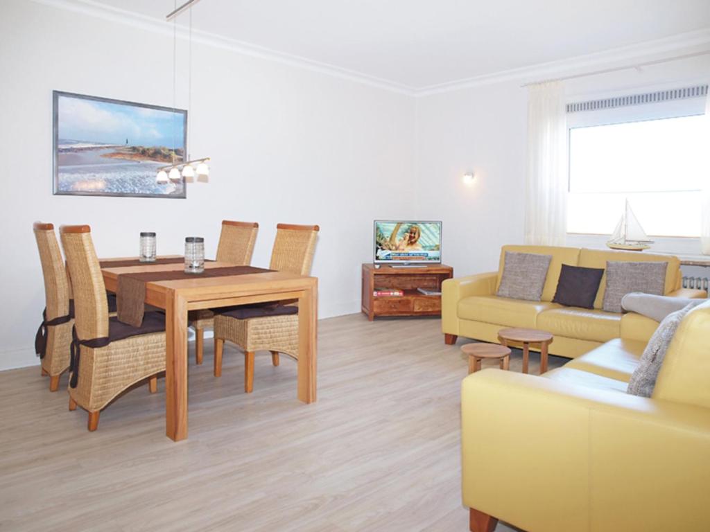 a living room with a dining table and a couch at Haus Strandkrabbe, Seehund in Döse