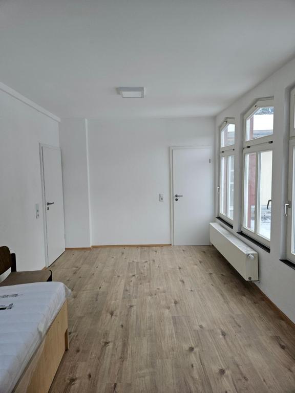 a white room with a bed and windows at Hotel Lahnblick in Weilburg