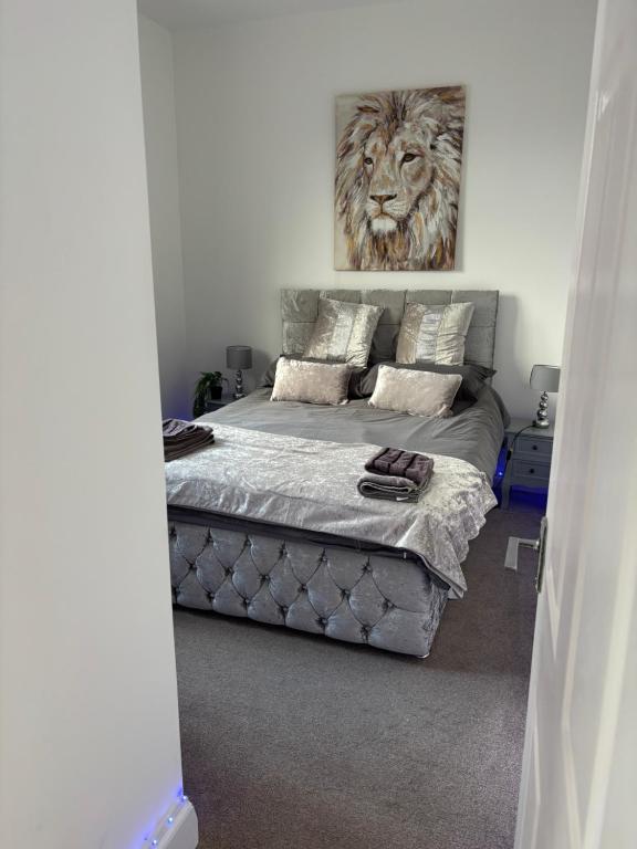 a bedroom with a bed with a lion painting on the wall at Stylish modern Cottage, Kidderminster in Kidderminster
