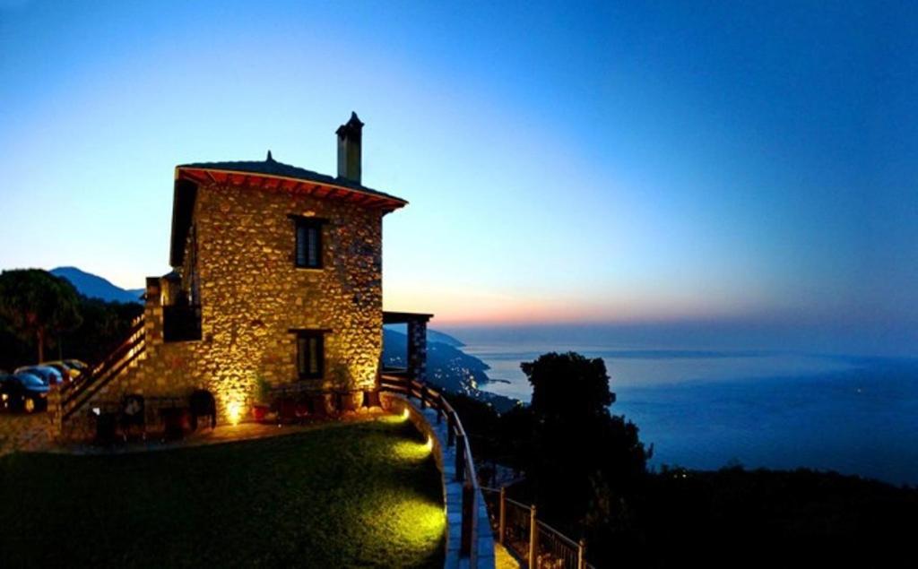 モウレシにあるPrasino - Galazioの海を背景にした丘の上の建物