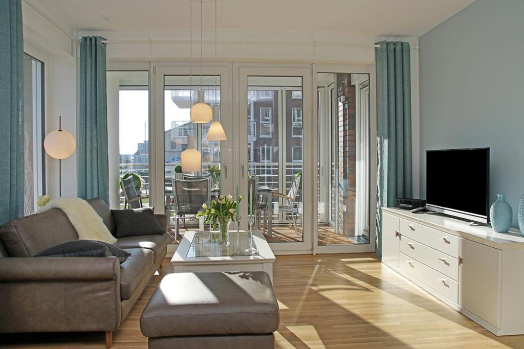 a living room with a couch and a television at Haus Yachthafen, Whg 4 in Cuxhaven