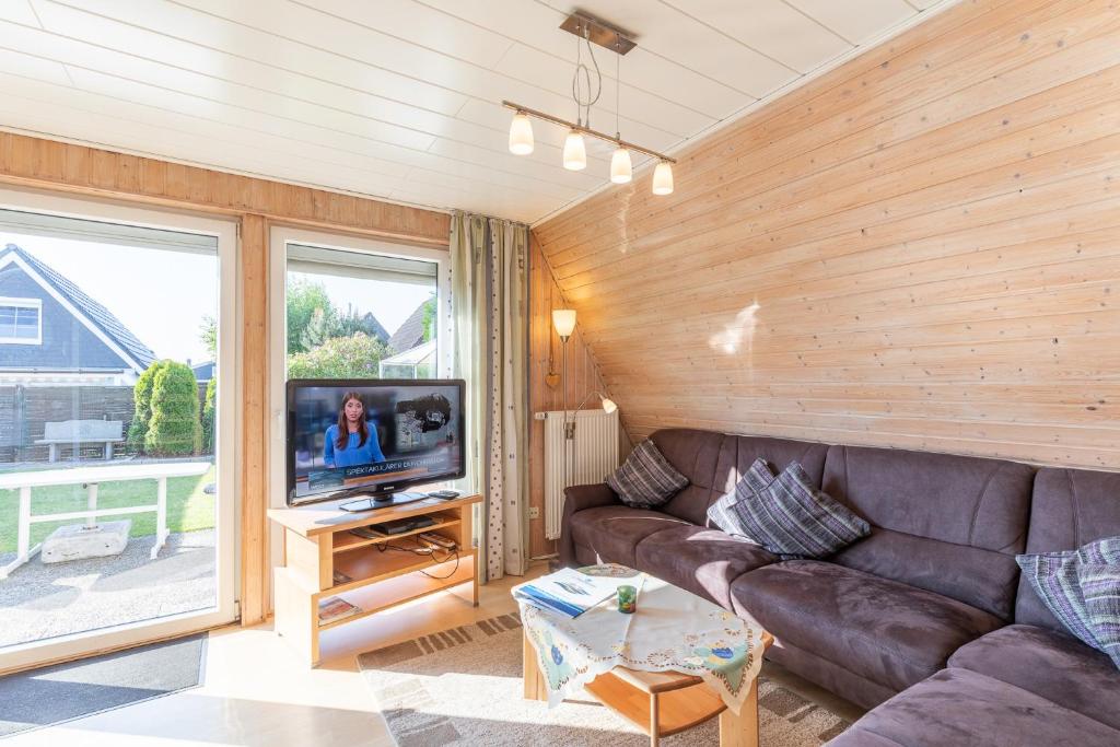 a living room with a leather couch and a television at Seegras in Cuxhaven