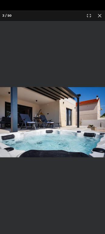 a large swimming pool in front of a house at Petra in Biograd na Moru