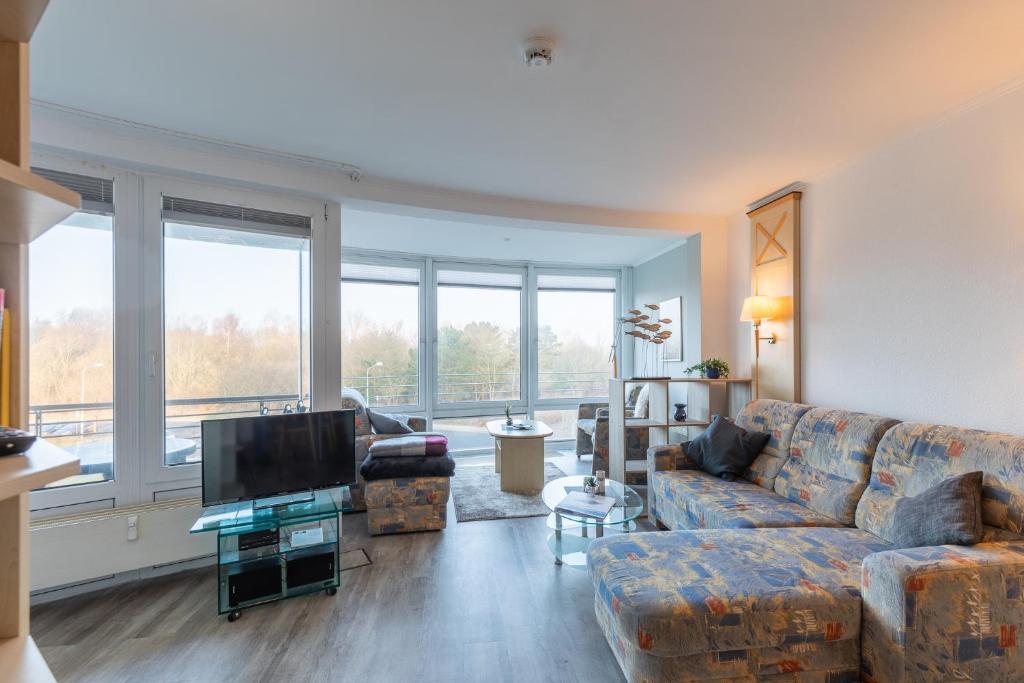 a living room with a couch and a flat screen tv at Kurpark Residenz, App 219b in Döse