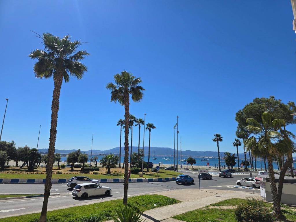a parking lot with palm trees and cars on a street at Bellavista in La Línea de la Concepción