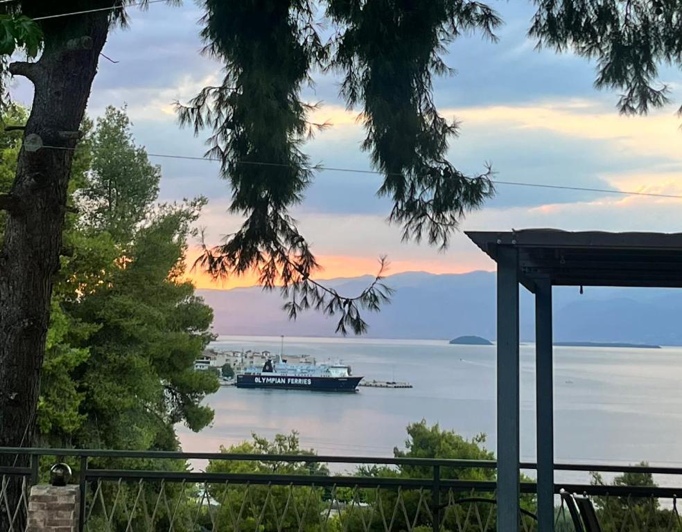 a boat on the water with a tree at Thalantheia House in Agios Konstantinos