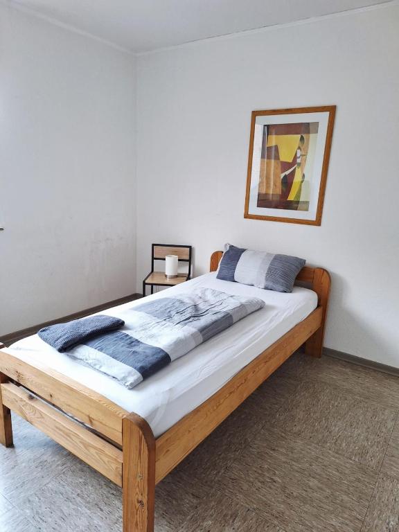 a bed in a bedroom with a picture on the wall at Gästezimmer B in Mönchengladbach