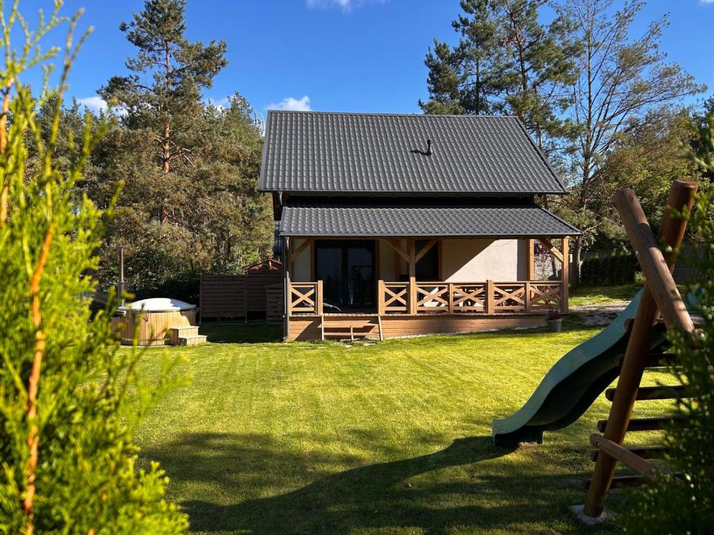een blokhut met een glijbaan in een tuin bij Domki Gorąca Bania in Gowidlino