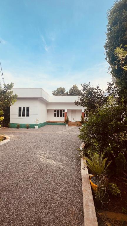a white building with black windows on a street at Green Villa Chirackal Gardens in Trichūr