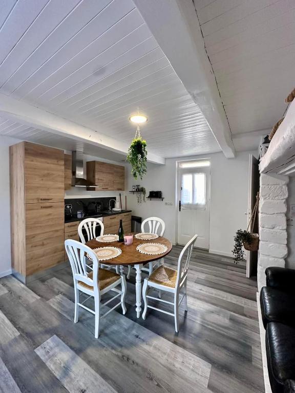 a kitchen and dining room with a table and chairs at Gite EGLANTINE in Saint-Rémy-Boscrocourt