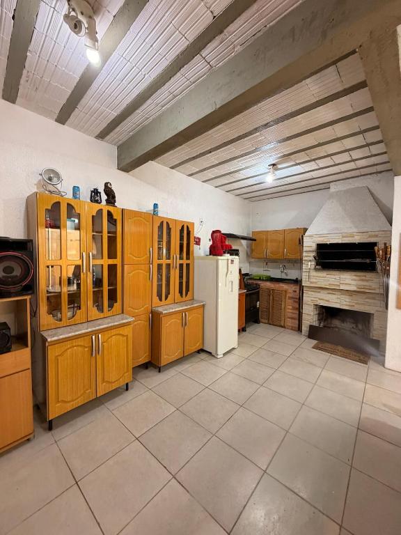 a large kitchen with wooden cabinets and a refrigerator at Casa privada no Centro in São Gabriel