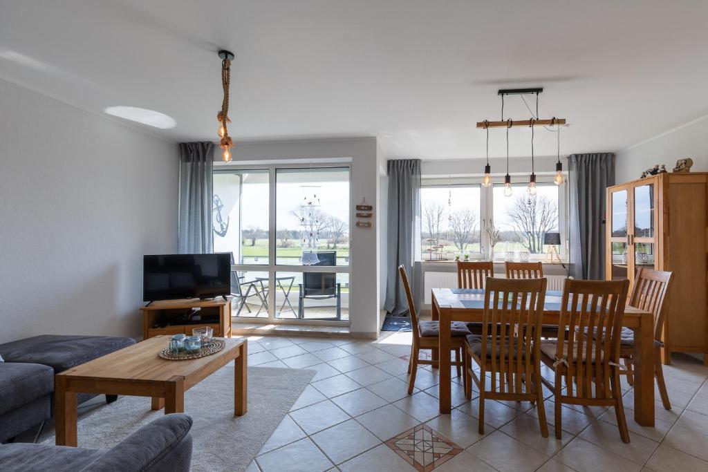a living room and dining room with a table and chairs at Haus Vogelsand, App 309 in Duhnen