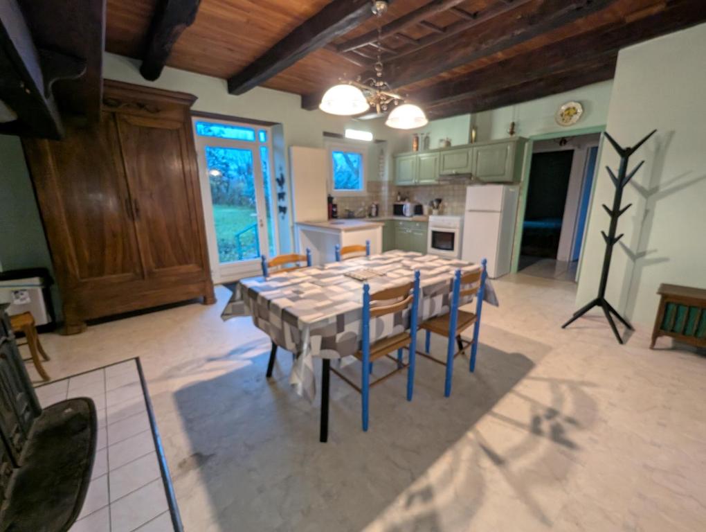 een keuken en eetkamer met een tafel en stoelen bij Gîte en pierre maison quercynoise in Vaylats