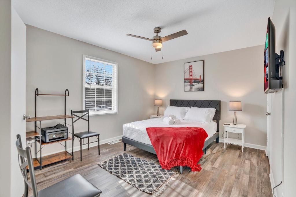a bedroom with a bed with a red blanket on it at Red Ranch Bring Your Dogs! Fenced Yard in Clarksville