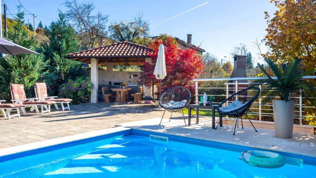 a patio with a table and chairs and a pool at Villa Lemily with private pool by Villas Guide in Matulji