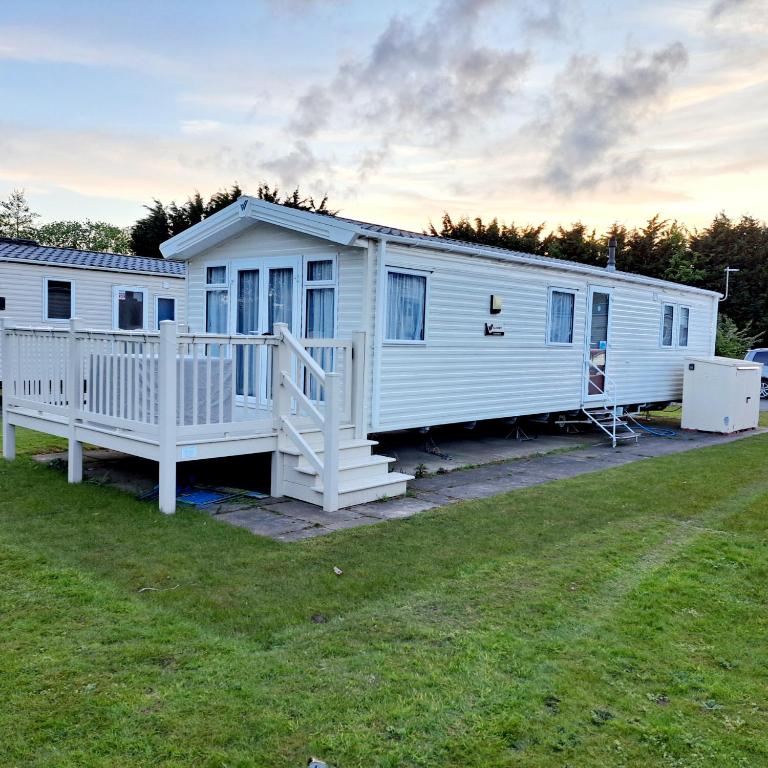 a large white mobile home with a porch at The vintage in Winthorpe