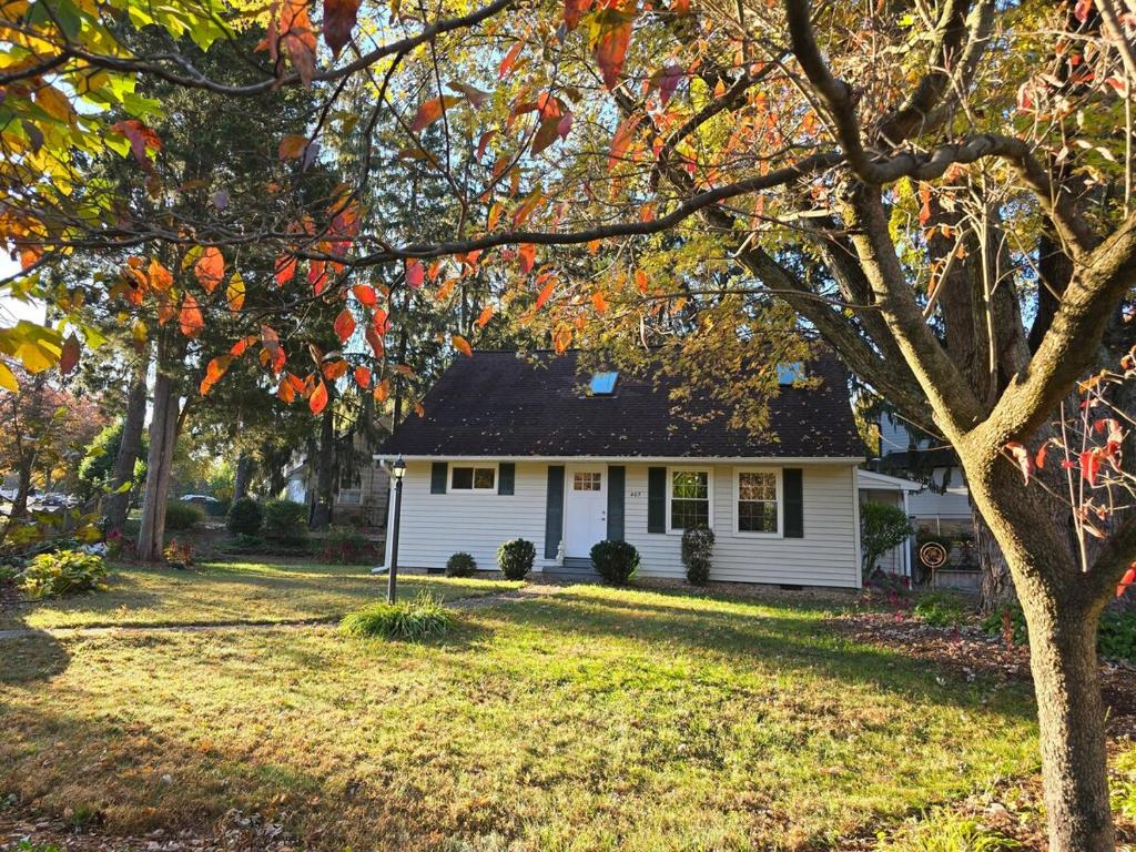 a white house with a tree in the yard at Park House Mada in Rockville