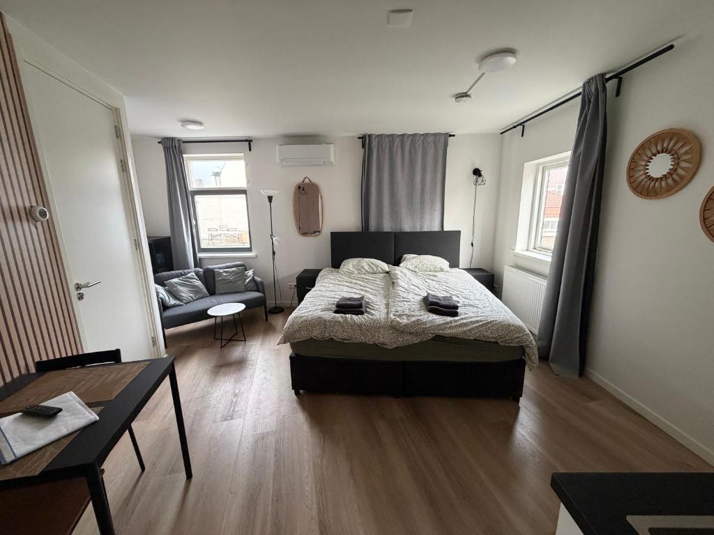 a bedroom with a bed and a living room at Apartement hotel Stays by ADM in Leiden