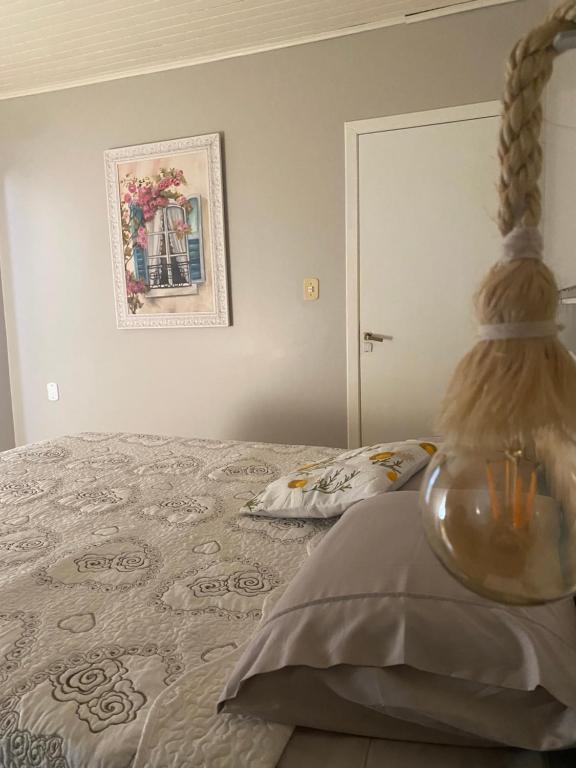 a bedroom with a bed and a picture on the wall at Suíte privativa quarto in Xaxim