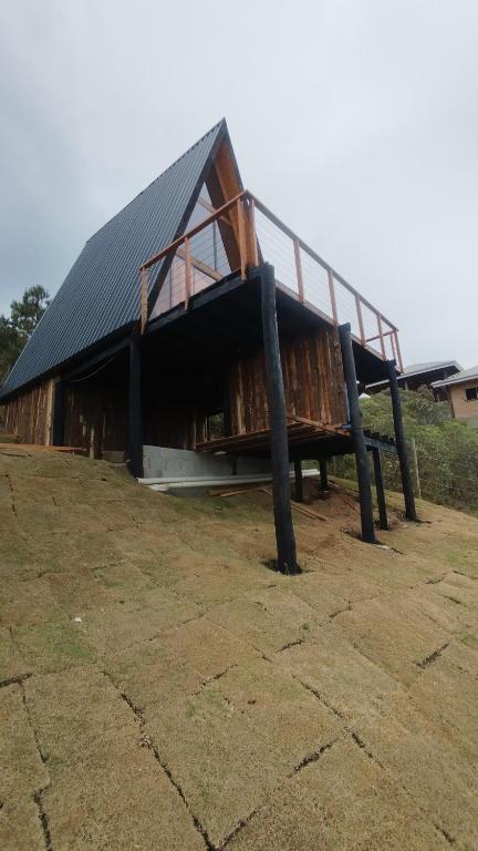 a large building with a metal roof on top at Chalé Colinas in Campos do Jordão