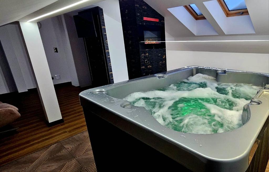a bath tub filled with water in a room at ZIBO APARTMENTS LESKO Nowoczesne apartamenty z jacuzzi i widokiem na Bieszczady in Lesko