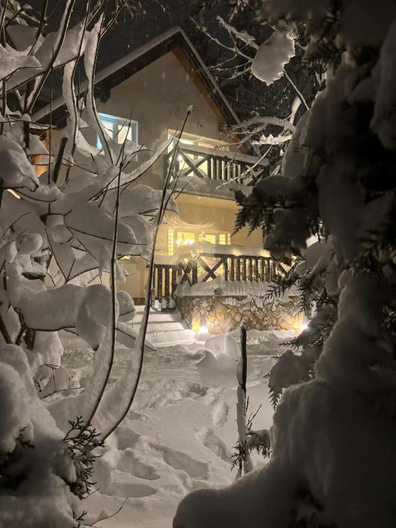 a snow covered yard with a house in the background at Villa Perle de la Montagne in Pale