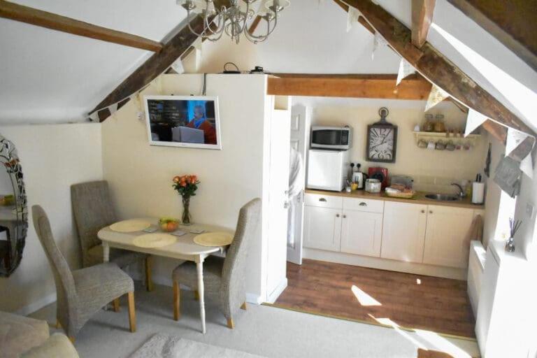 a kitchen and dining room with a table and chairs at Pitfield Apartments in Willand