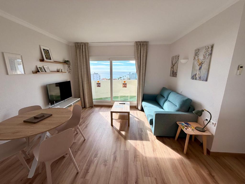a living room with a blue couch and a table at Kingfisher Apartments Benal Beach in Benalmádena