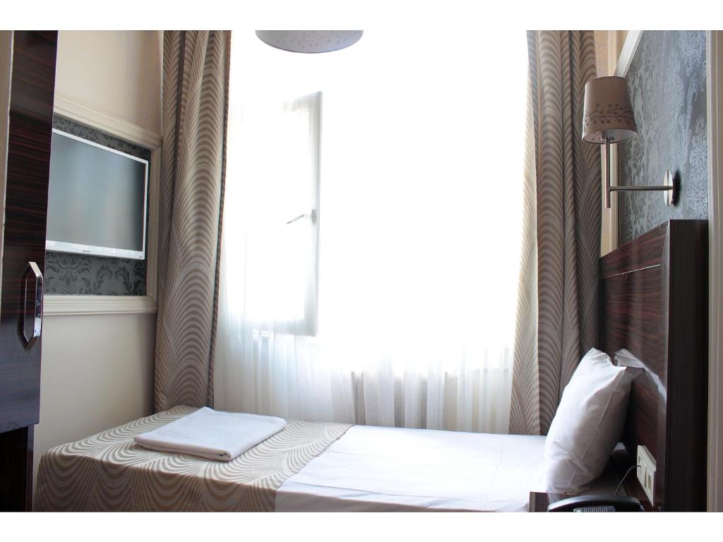 a small bedroom with a bed with a window at Venus Hotel Taksim in Istanbul