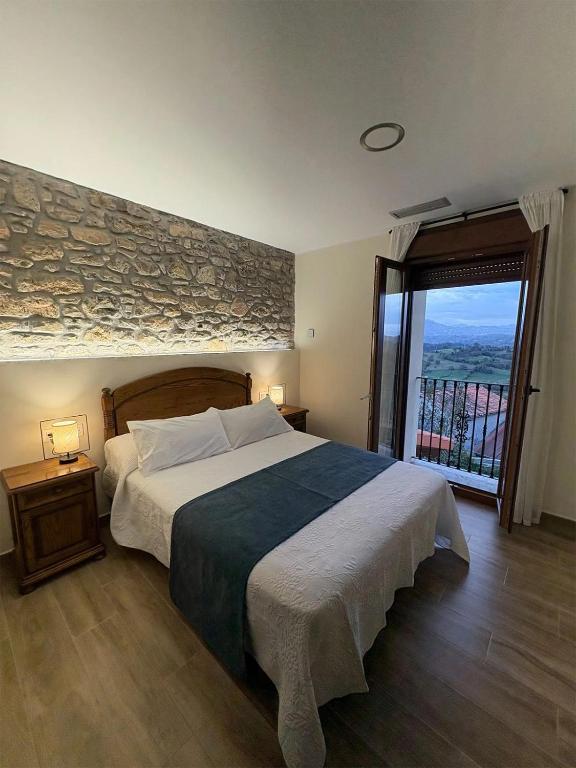 a bedroom with a large bed and a large window at Apartamentos Rurales Sariar in Villar