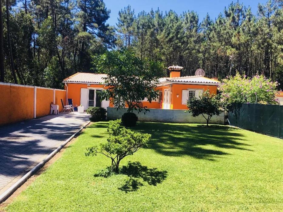 an orange house with a green lawn in front of it at Quinta do Marnoto in Gafanha do Carmo