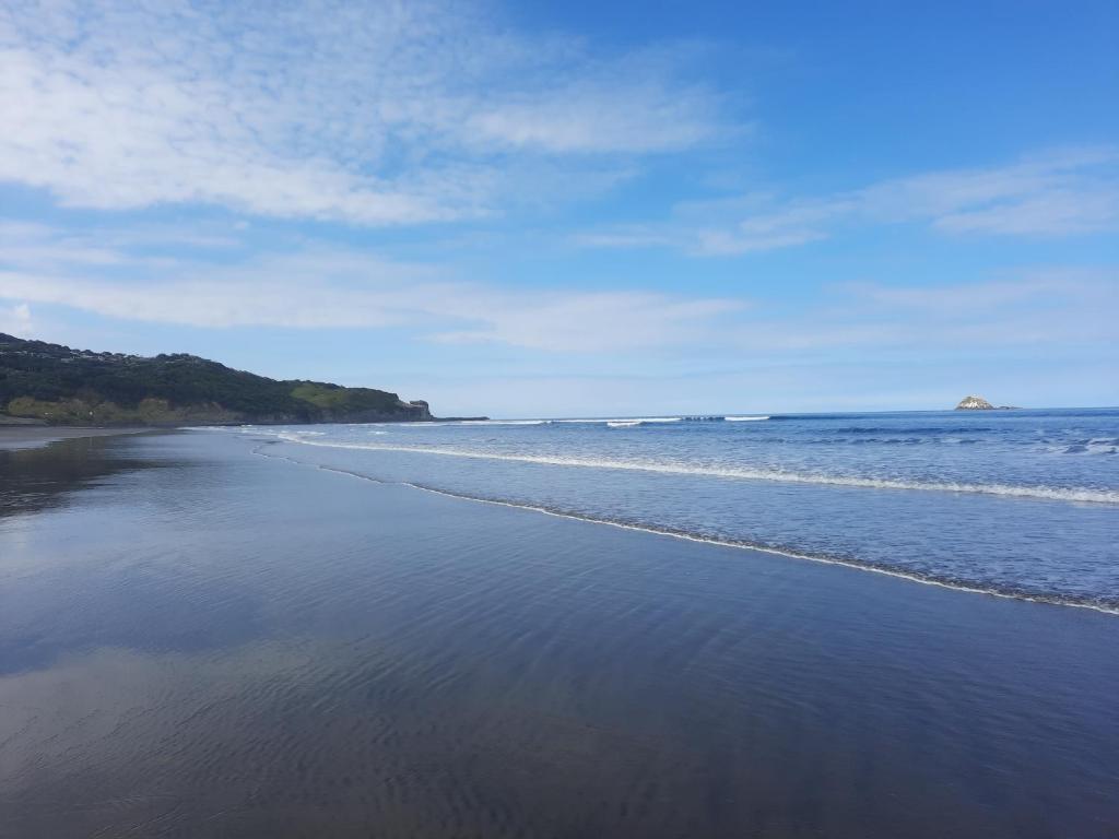 a view of the shore of a beach at Silver Seas Retreat in Muriwai Beach