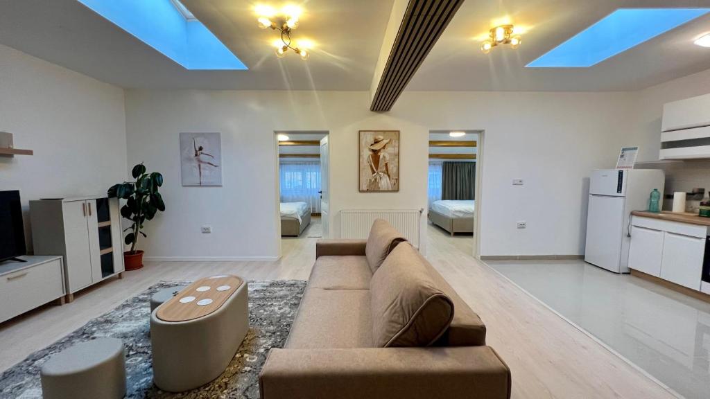 a living room with a couch and a kitchen at Parc Vatra Dornei - The 7th Haven in Vatra Dornei