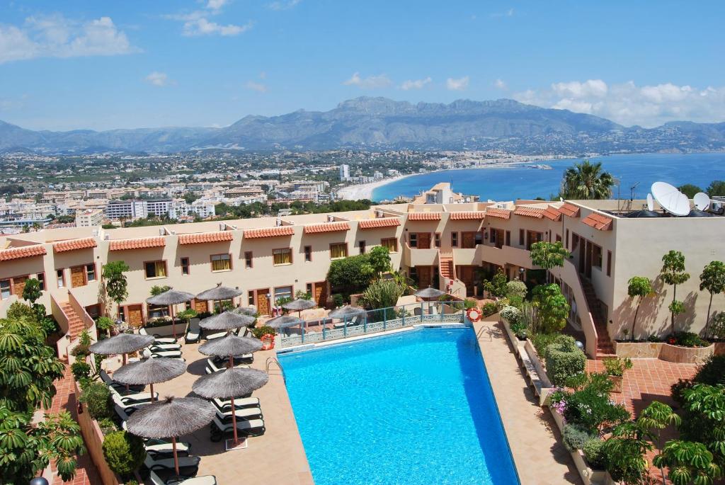 a view of a hotel with a swimming pool and umbrellas at Albir Hills Apartments in Albir